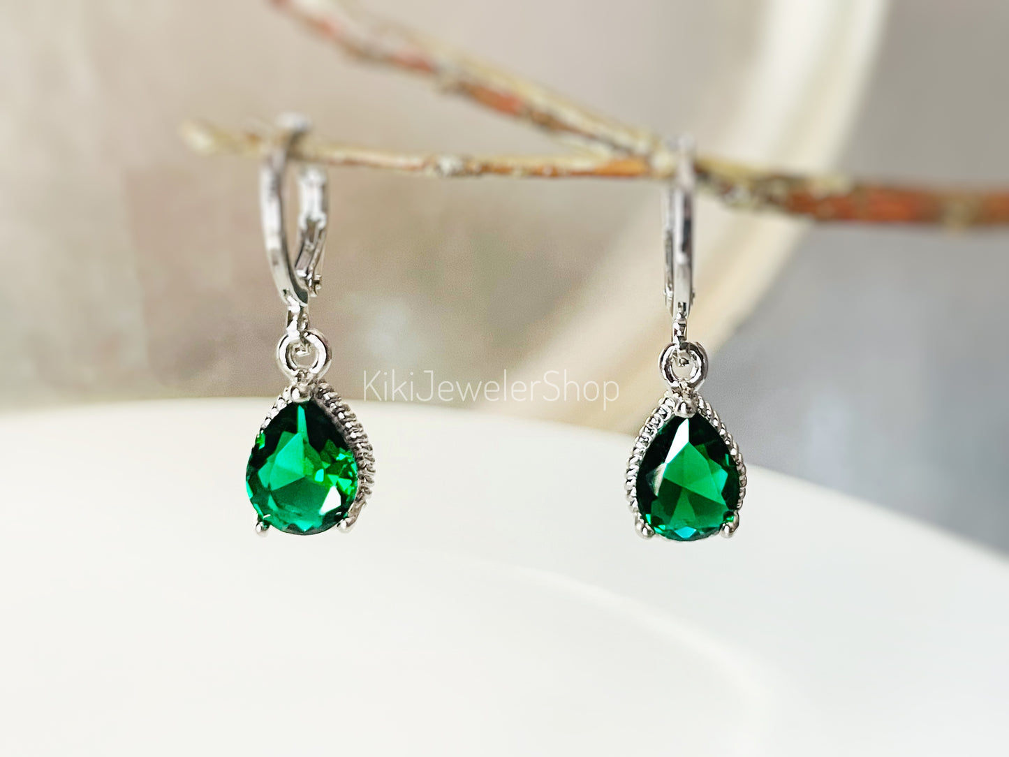 Petites boucles d'oreilles pendantes en émeraude sertie clos, ornées d'une pierre précieuse verte en forme de larme. Cadeau pour elle ou pour une jeune fille. Pierre de naissance du mois de mai.