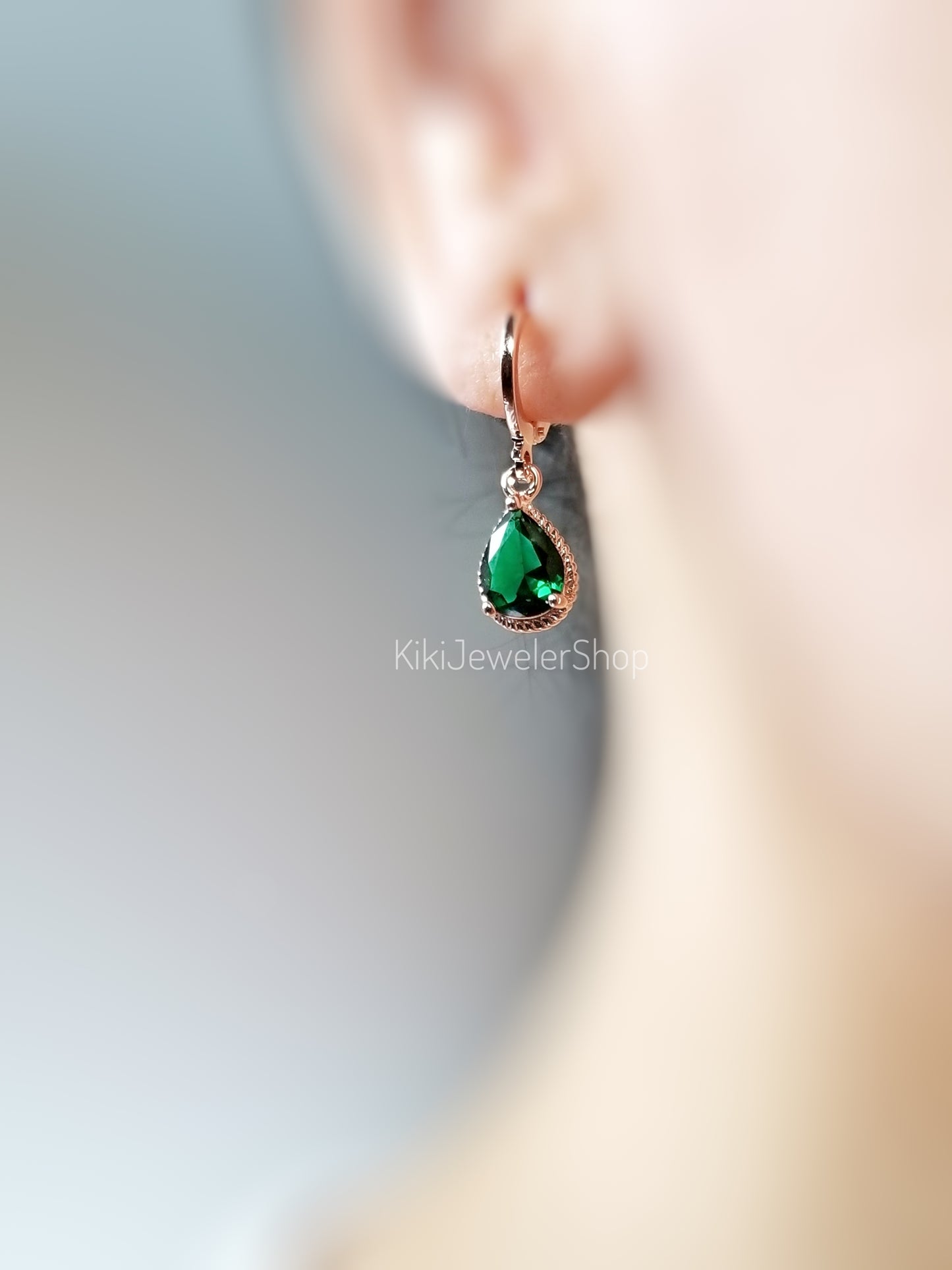 Petites boucles d'oreilles pendantes en émeraude sertie clos, ornées d'une pierre précieuse verte en forme de larme. Cadeau pour elle ou pour une jeune fille. Pierre de naissance du mois de mai.